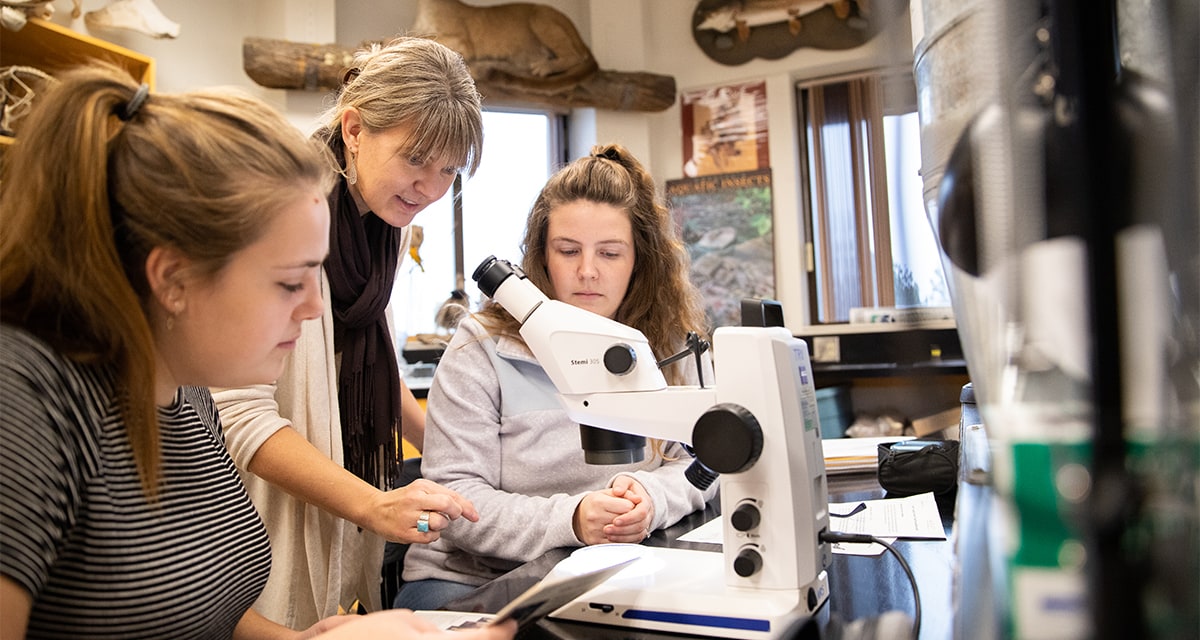 Students with instructor and microscope